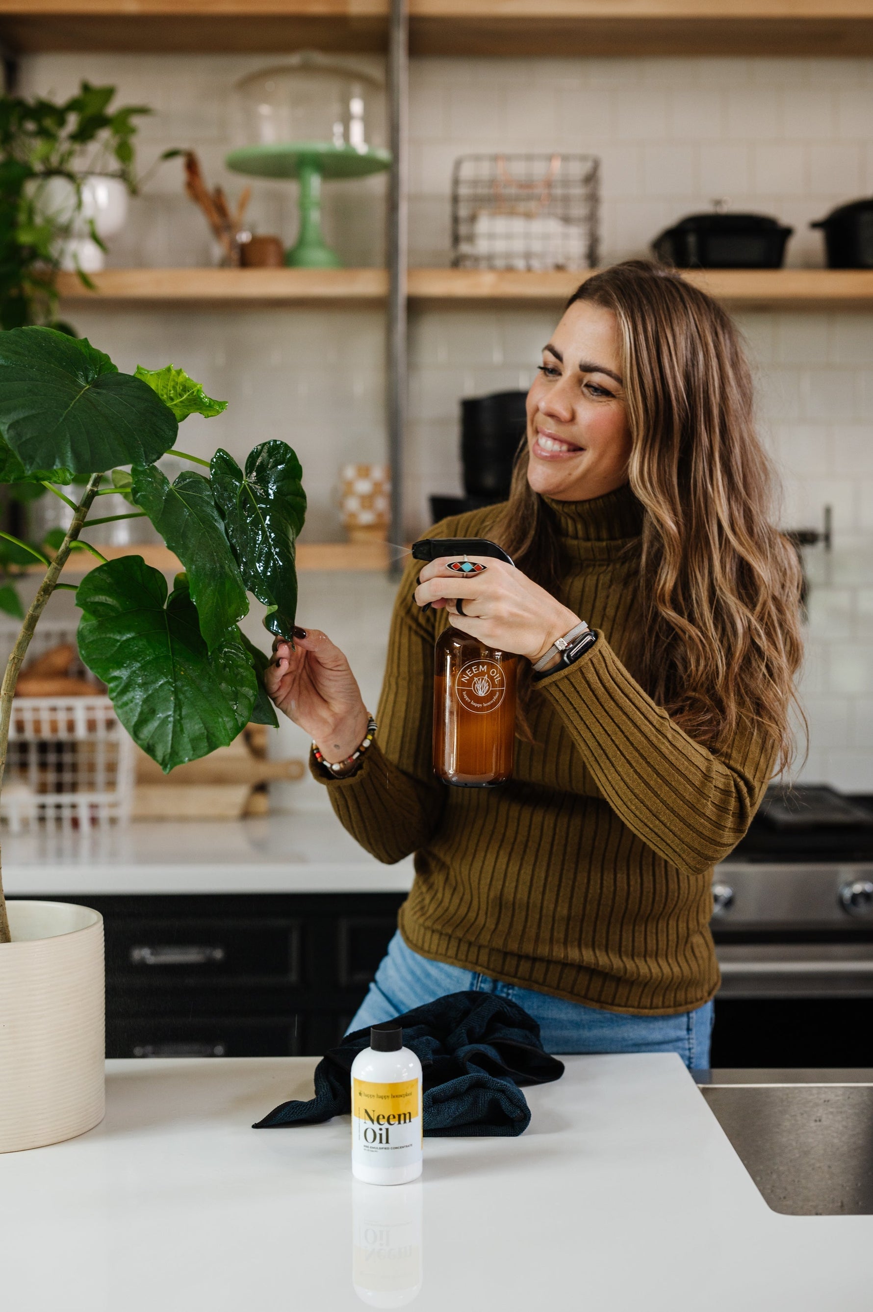 Mandi Gubler uses a neem oil spray to treat his indoor house plant